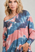 Woman wearing a tie-dye sweater with pink and blue patterns on a plain background