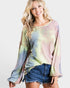 Woman wearing a tie-dye long-sleeve top and denim shorts on a white background
