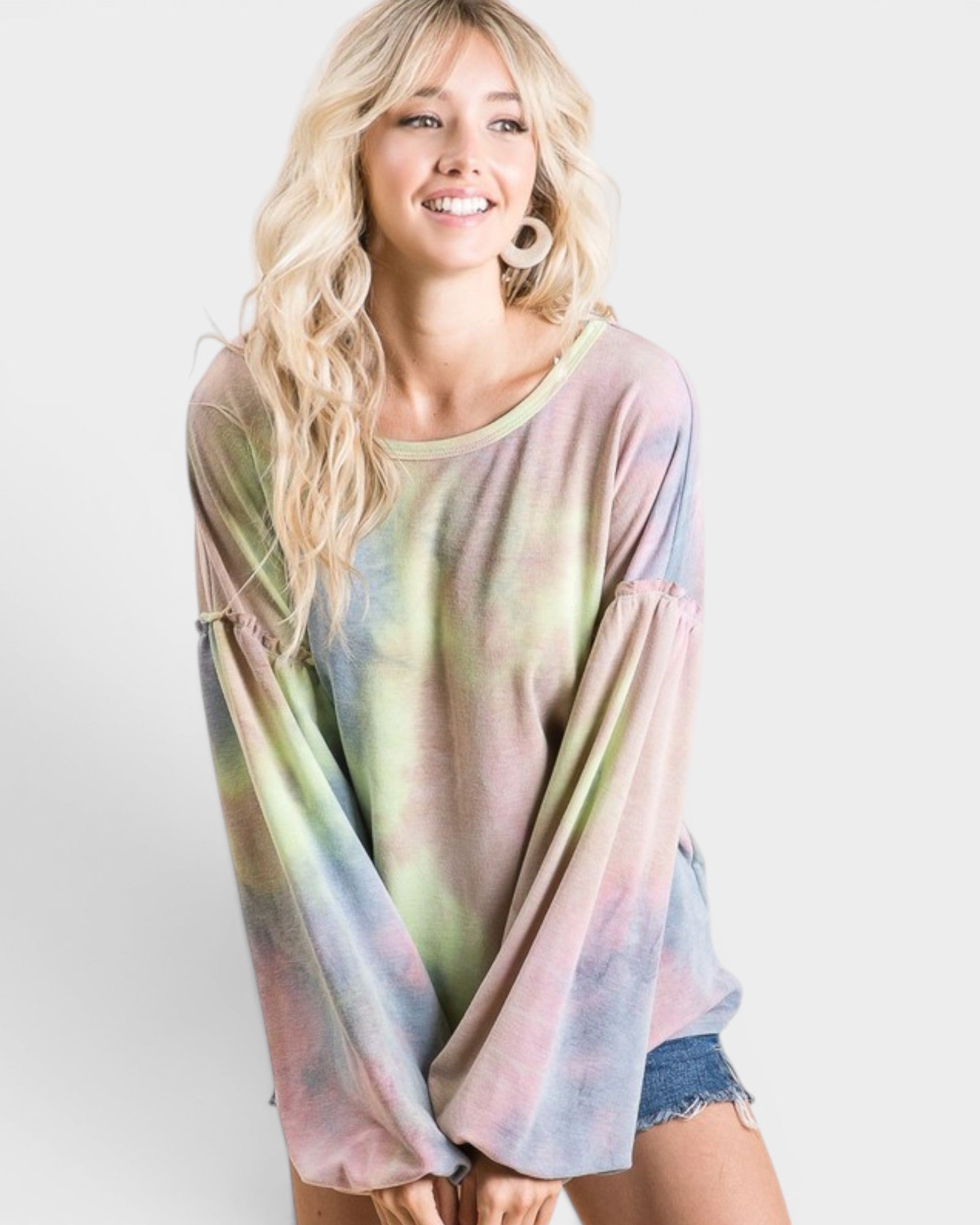 Woman wearing a tie-dye shirt with pastel colors on a white background