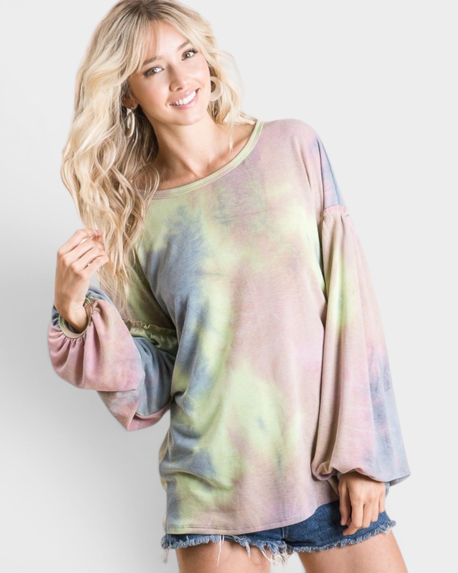 Woman wearing a tie-dye long-sleeve top against a plain background