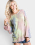 Woman wearing a tie-dye long-sleeve top against a plain background