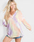 Woman wearing a tie-dye blouse with a plain background