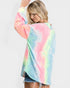 Woman wearing a colorful tie-dye shirt against a plain background