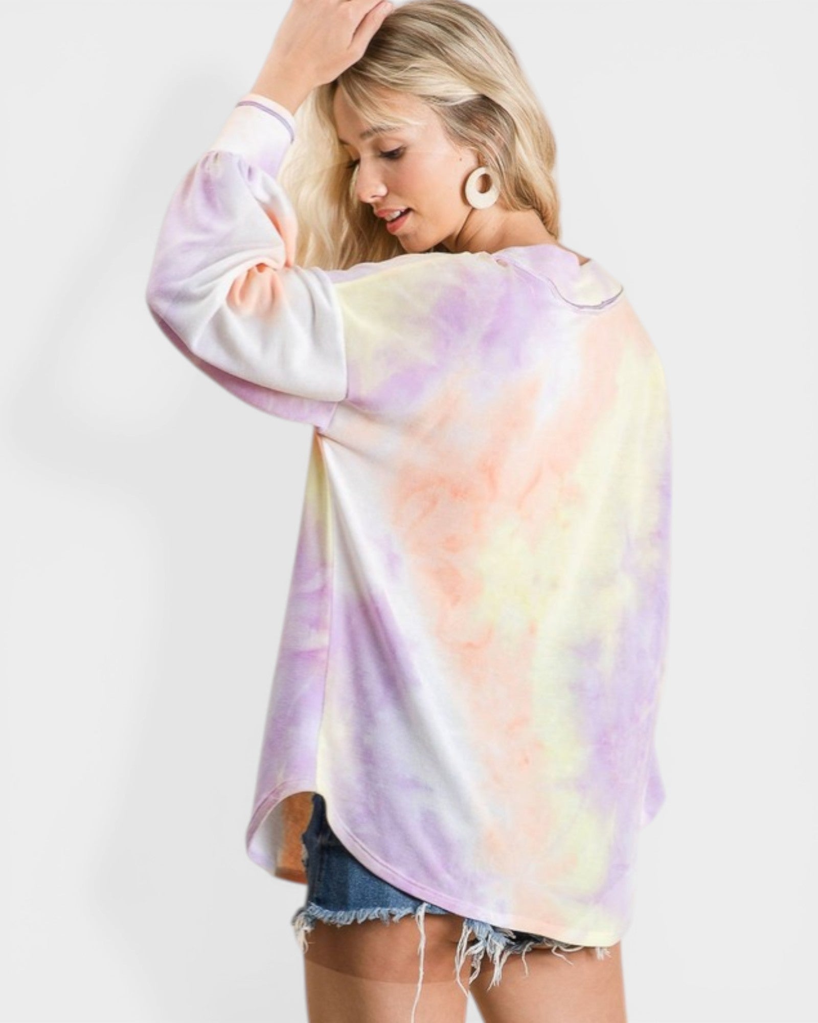 Woman wearing a tie-dye shirt with a white background