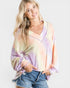 Woman wearing a tie-dye long-sleeve top with a plain background