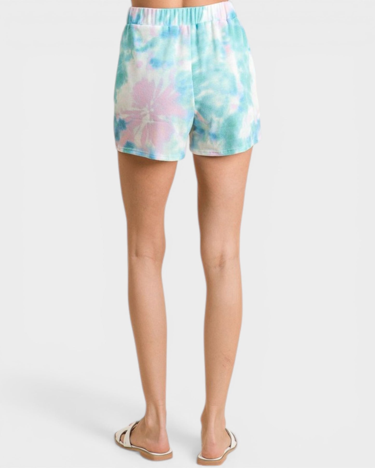 Tie-dye shorts worn by a person on a white background