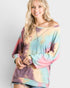 Woman wearing a tie-dye sweater against a plain background