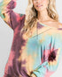 Person wearing a tie-dye long-sleeve top with a plain background