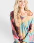 Woman wearing a colorful tie-dye long-sleeve top on a white background