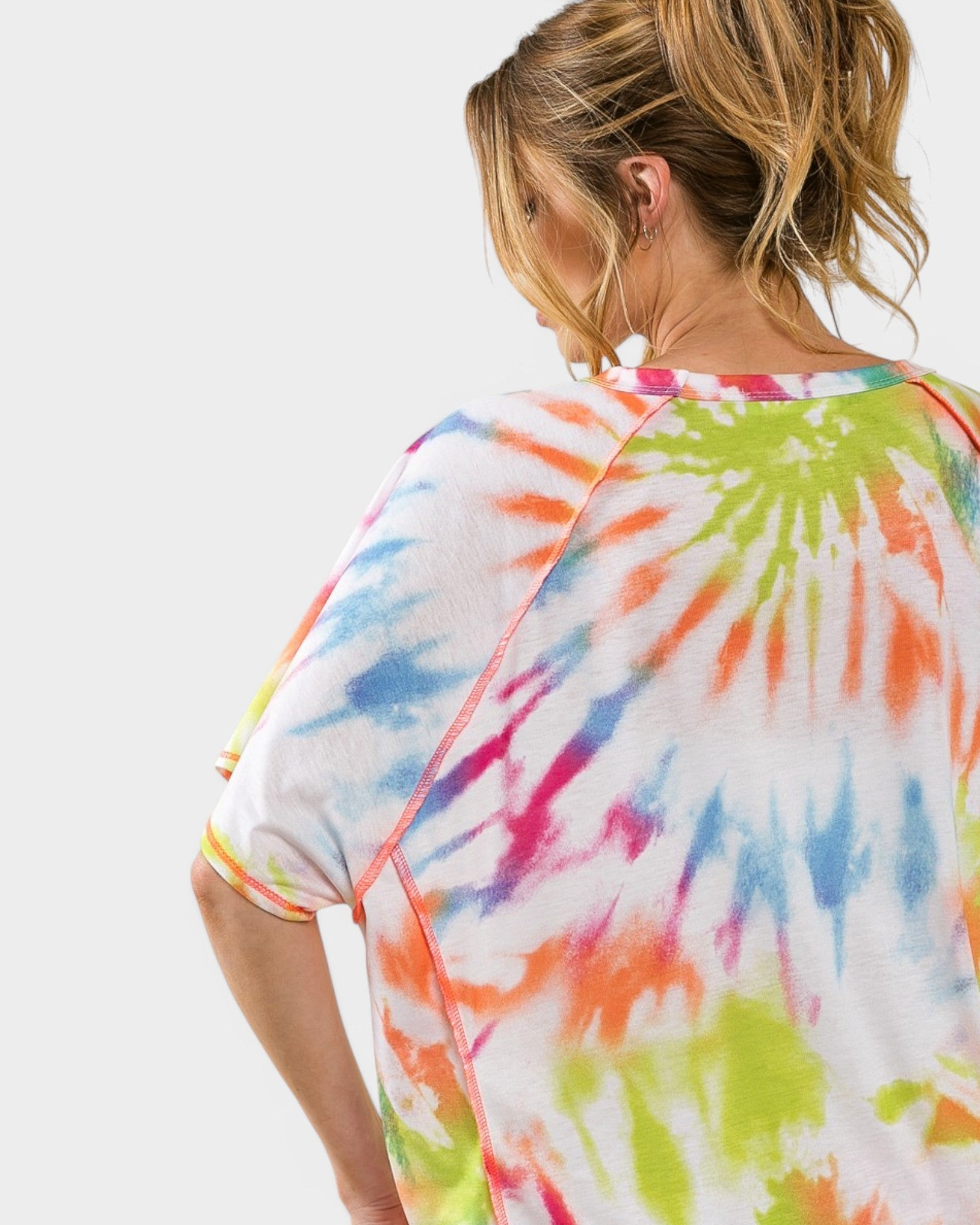 Person wearing a colorful tie-dye shirt on a white background