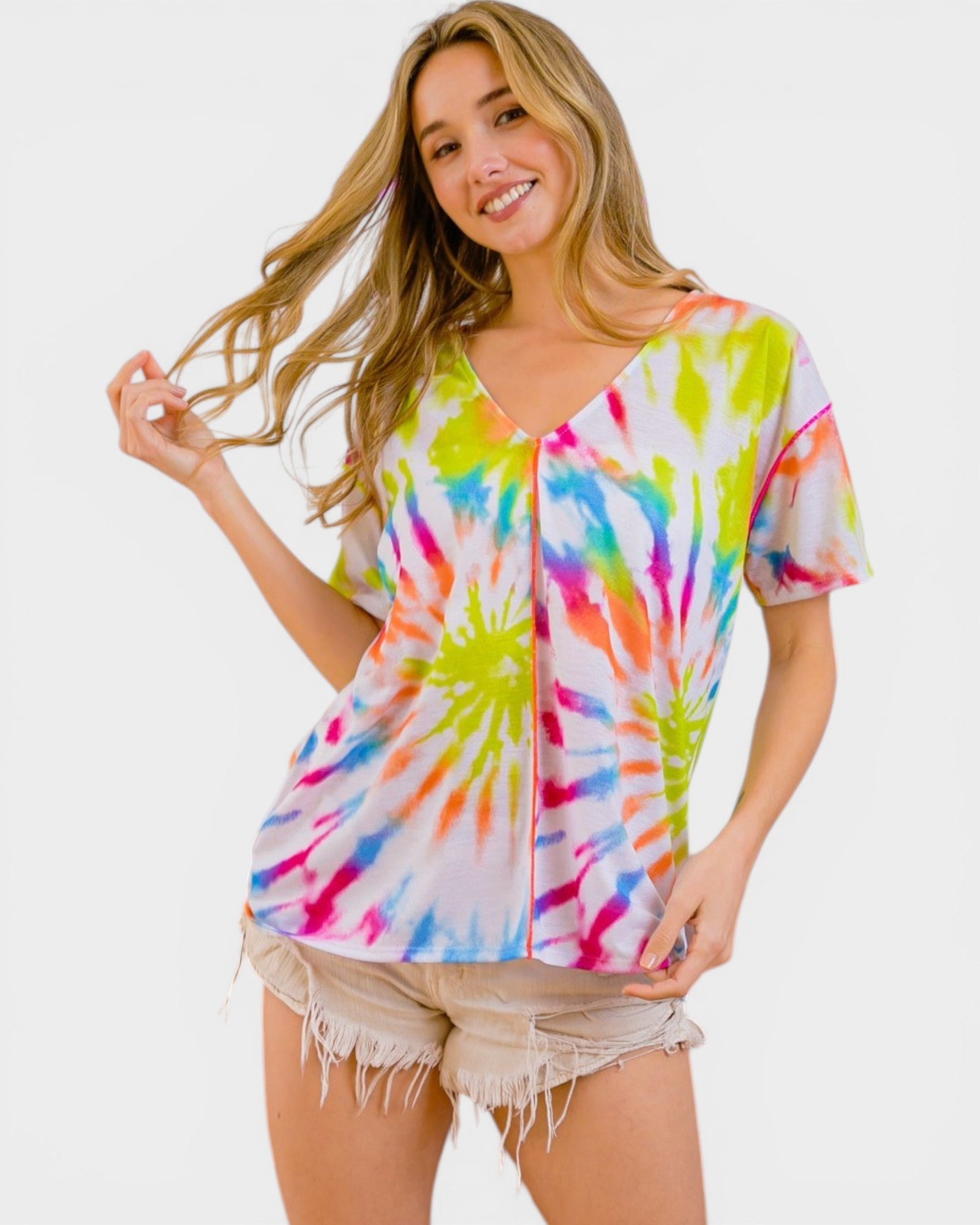 Woman wearing a colorful tie-dye shirt on a white background