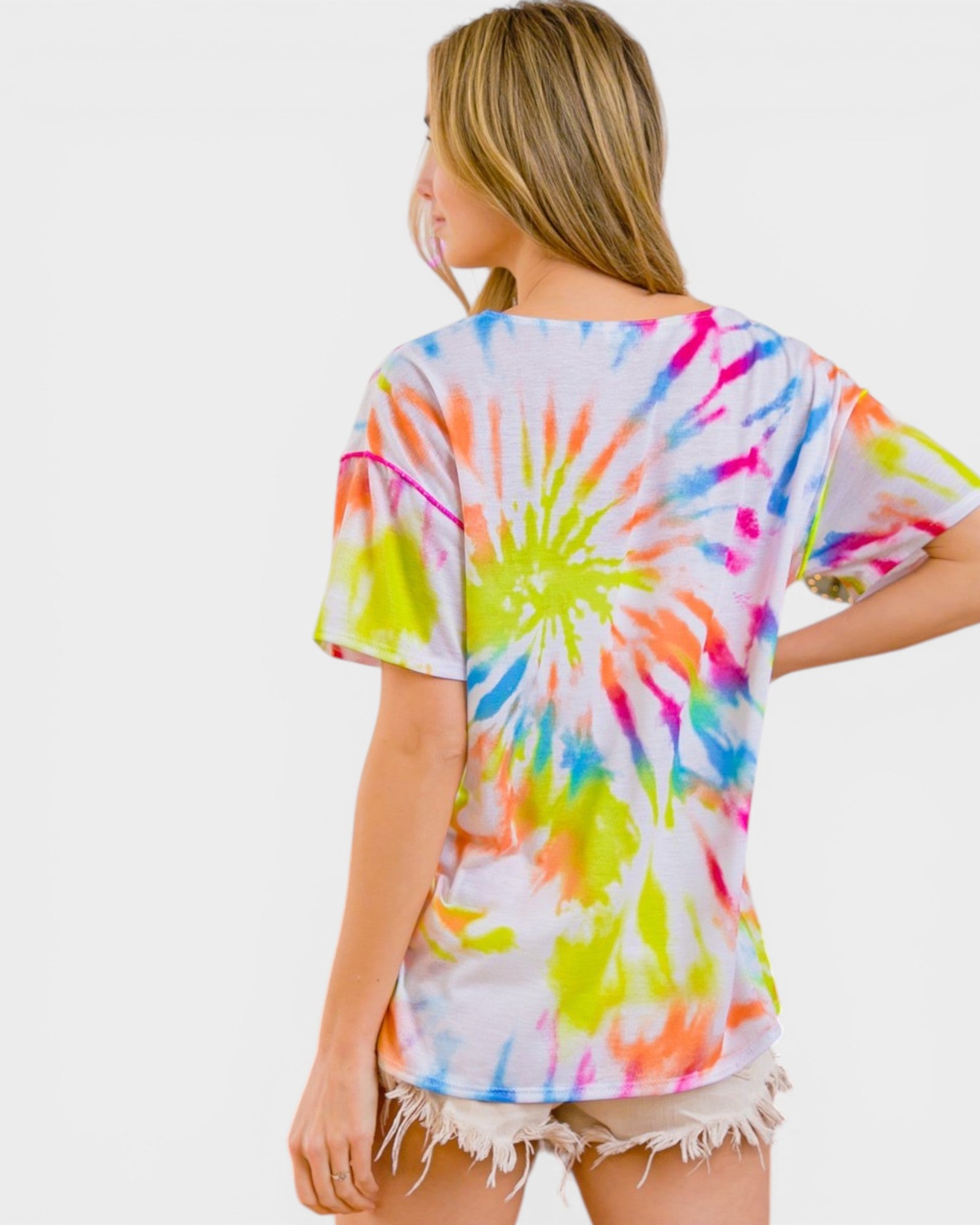 Person wearing a colorful tie-dye shirt on a white background