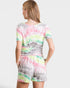 Woman wearing a colorful tie-dye romper on a white background
