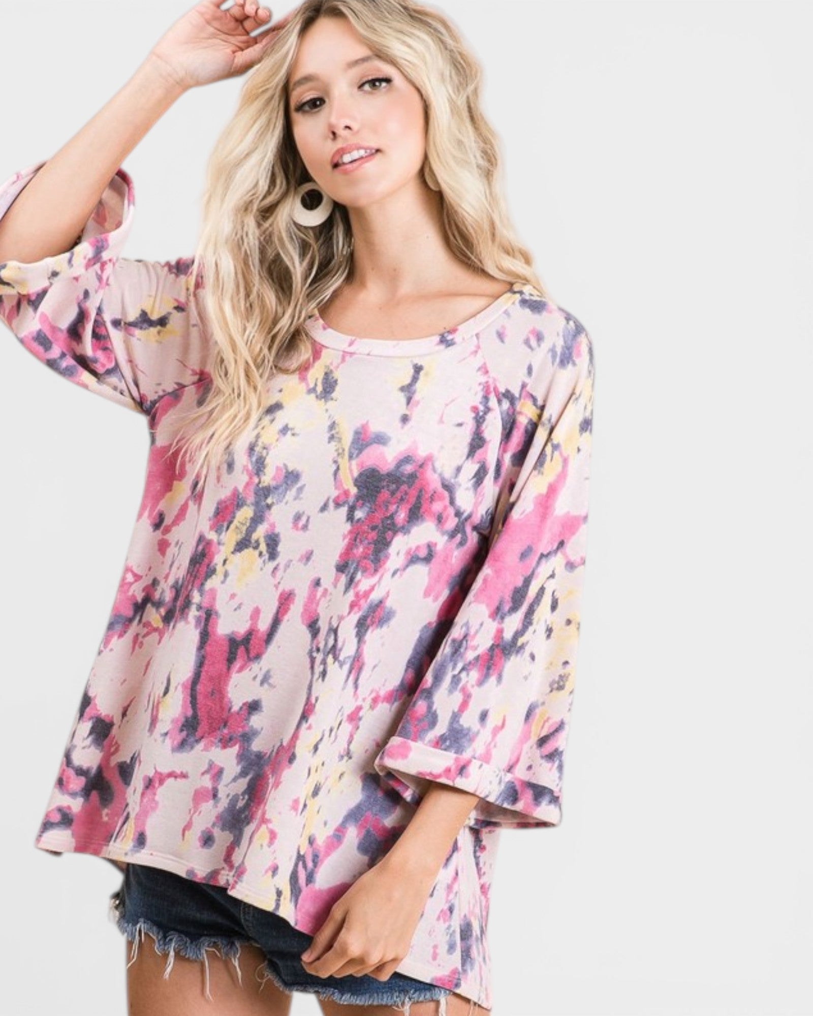 Woman wearing a colorful, patterned top on a white background