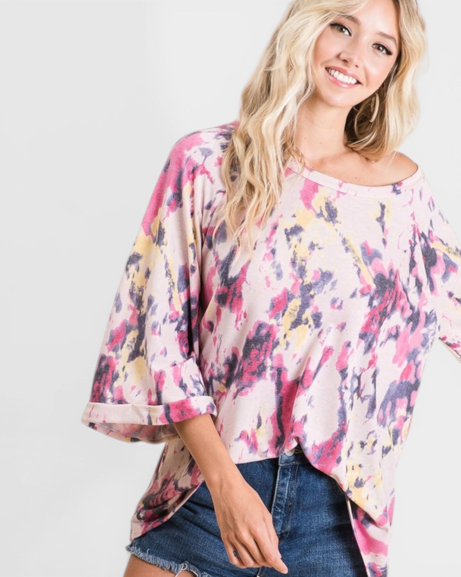 Woman wearing a colorful floral blouse with a plain background