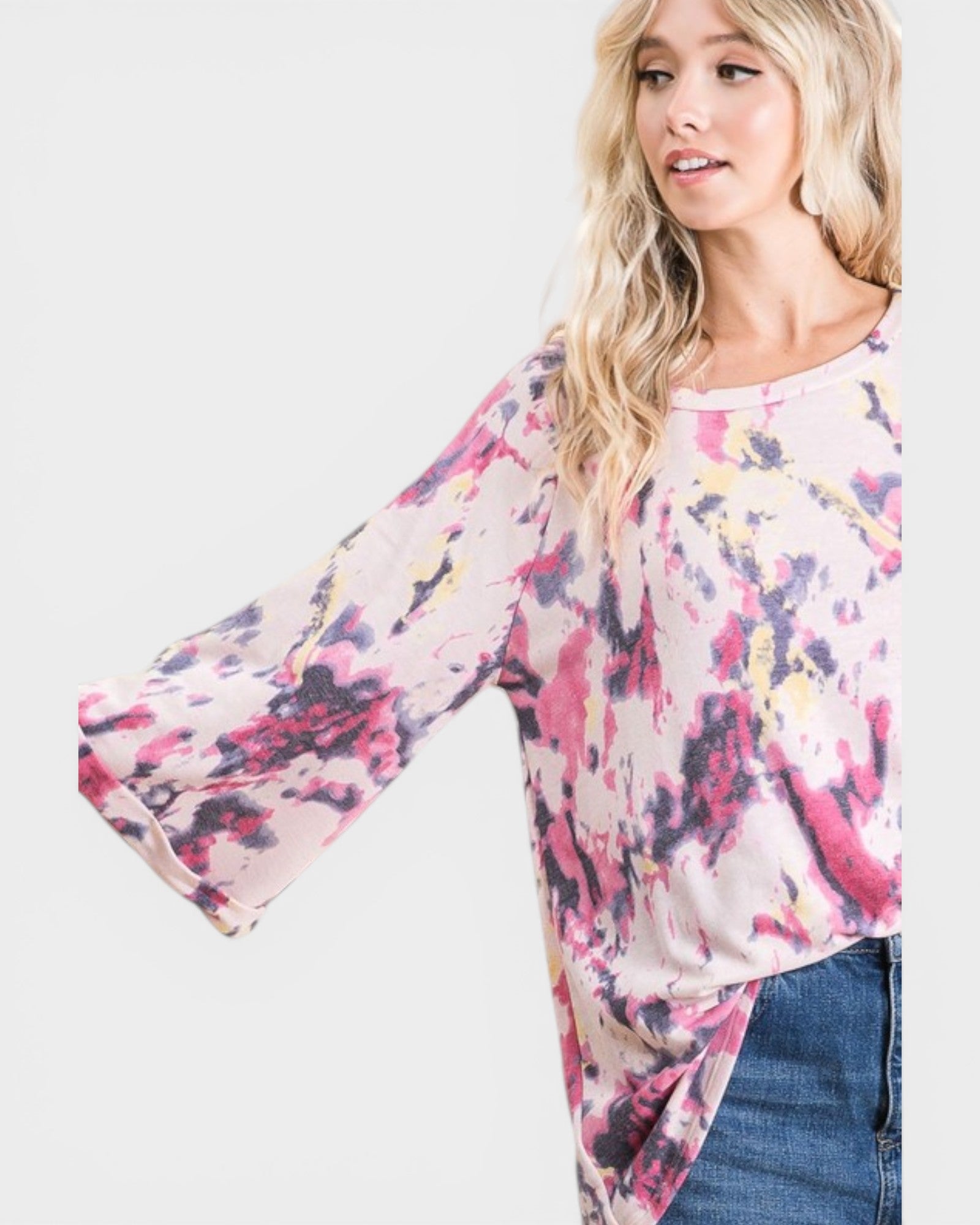Woman wearing a colorful floral blouse with bell sleeves on a white background