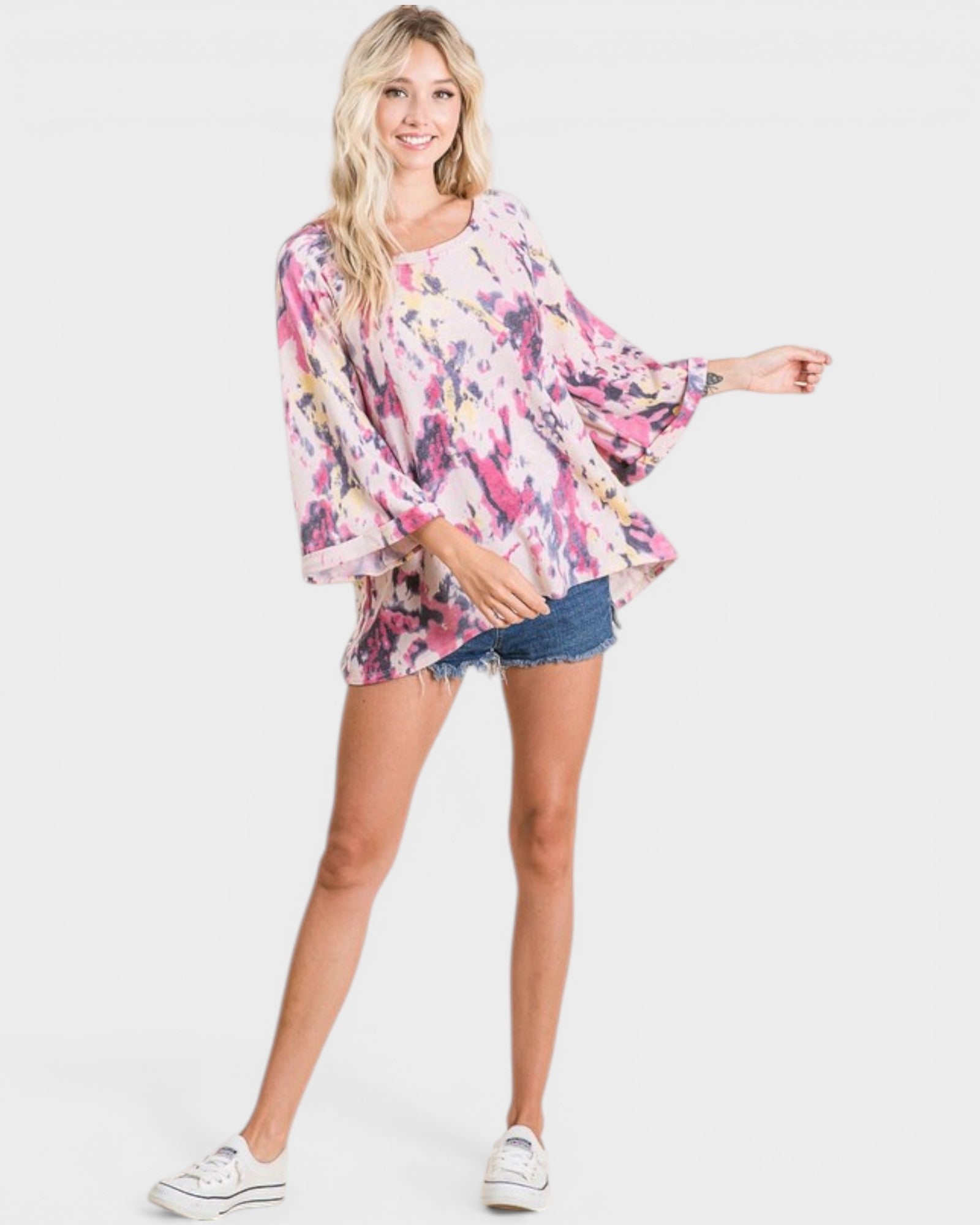 Woman wearing a floral blouse and denim shorts on a white background