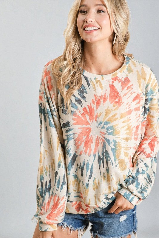 Woman wearing a tie-dye long-sleeve shirt with a gray background