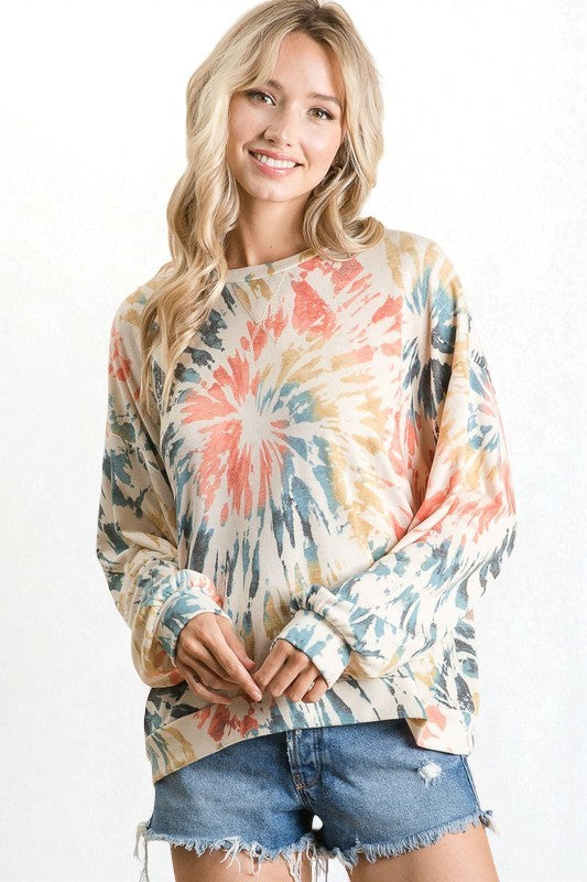 Woman wearing a tie-dye sweatshirt with a white background