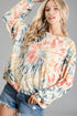 Woman wearing a tie-dye long-sleeve top with a gray background