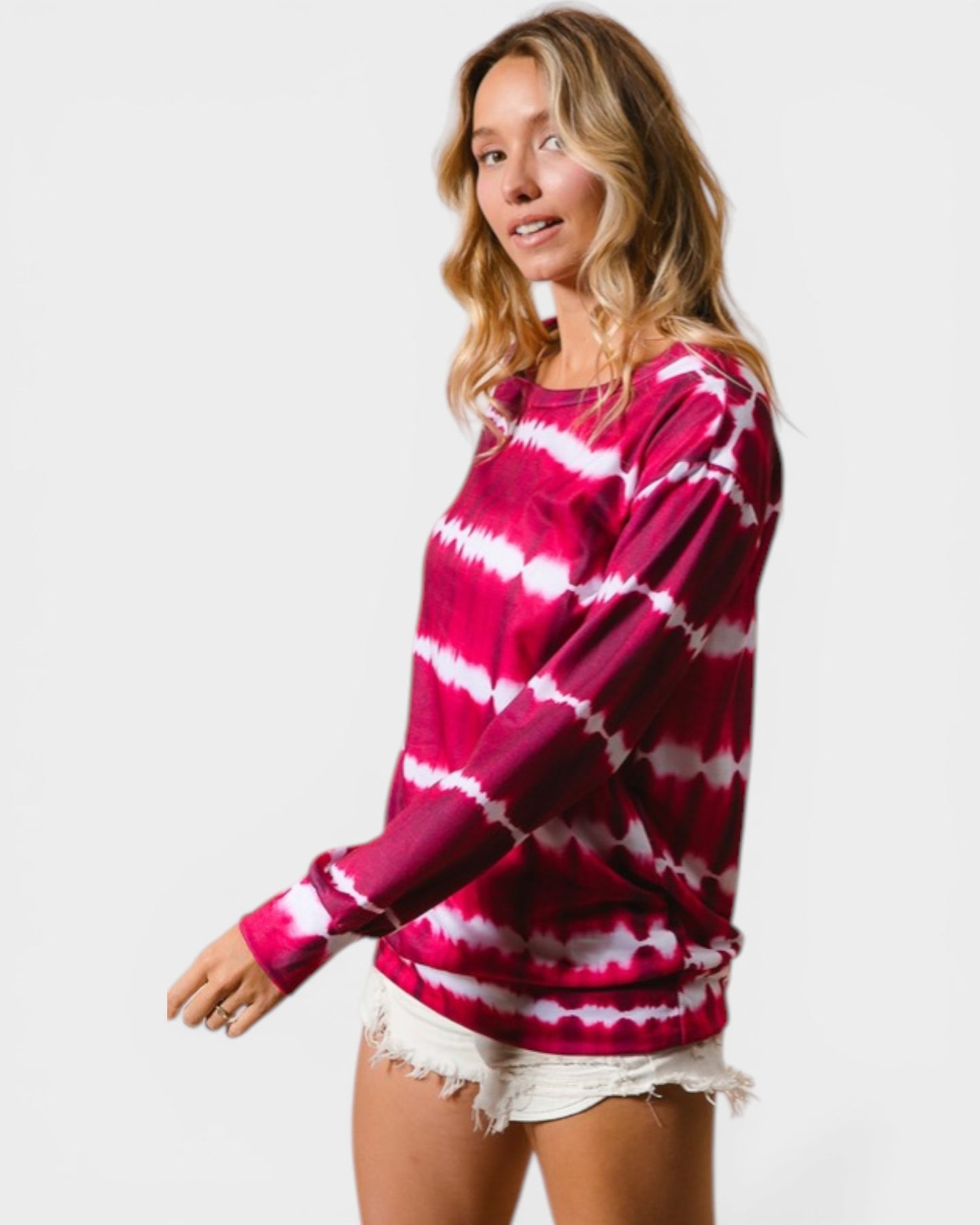 Woman wearing a pink and white tie-dye sweater on a plain background
