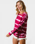 Woman wearing a pink and white tie-dye sweater on a plain background