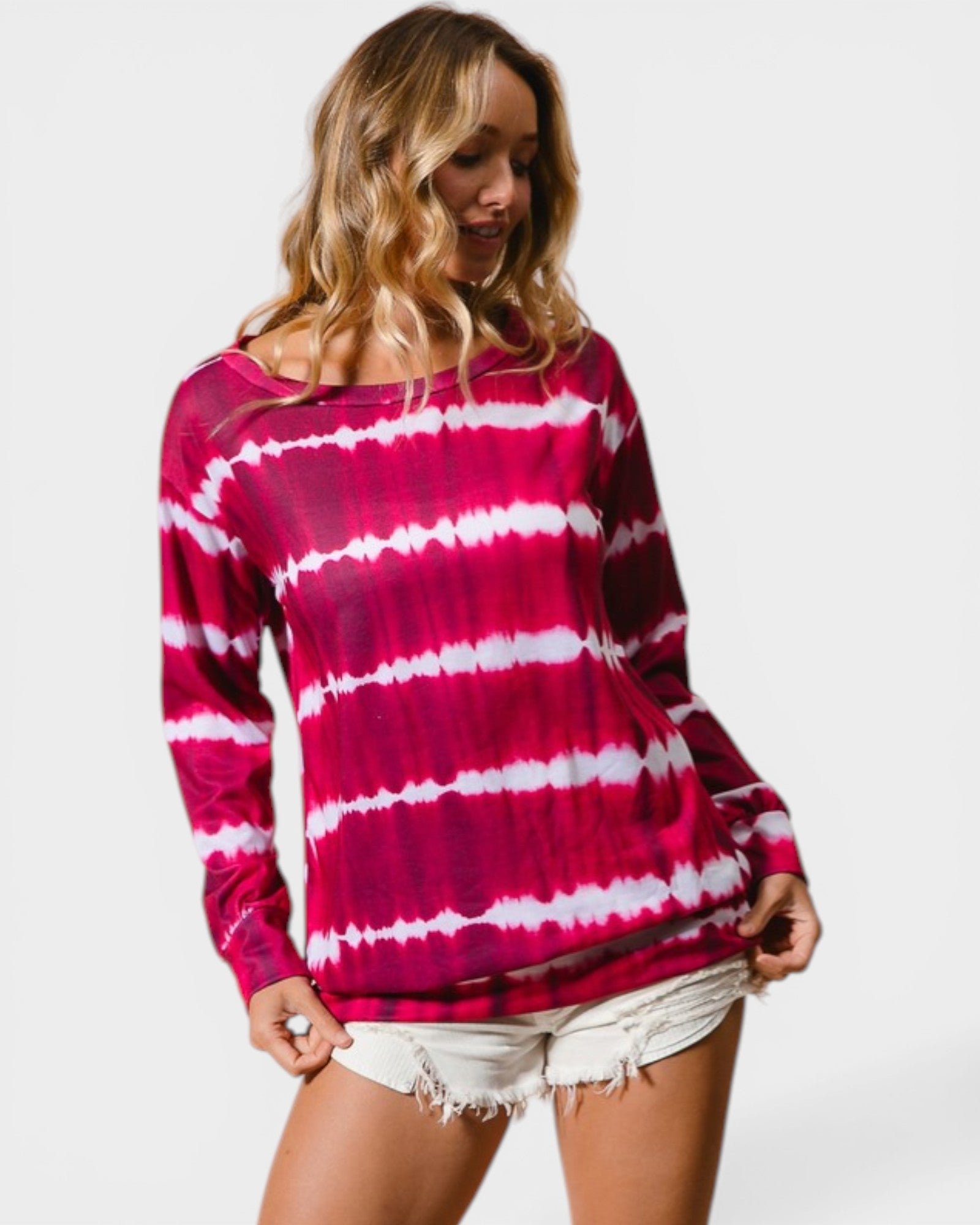 Woman wearing a pink and white tie-dye long-sleeve top on a plain background