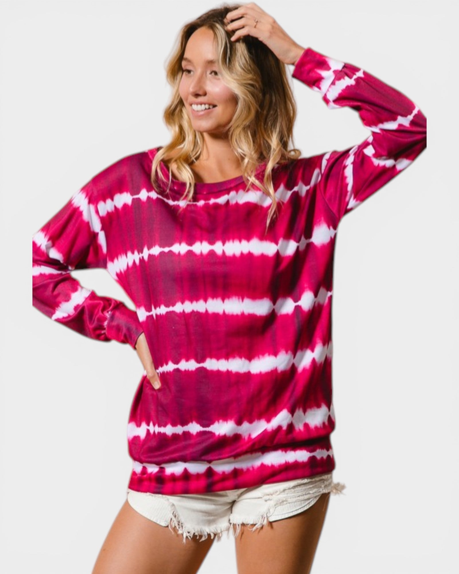 Woman wearing a pink and white tie-dye long-sleeve shirt on a white background