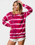 Woman wearing a pink and white tie-dye long-sleeve shirt on a white background