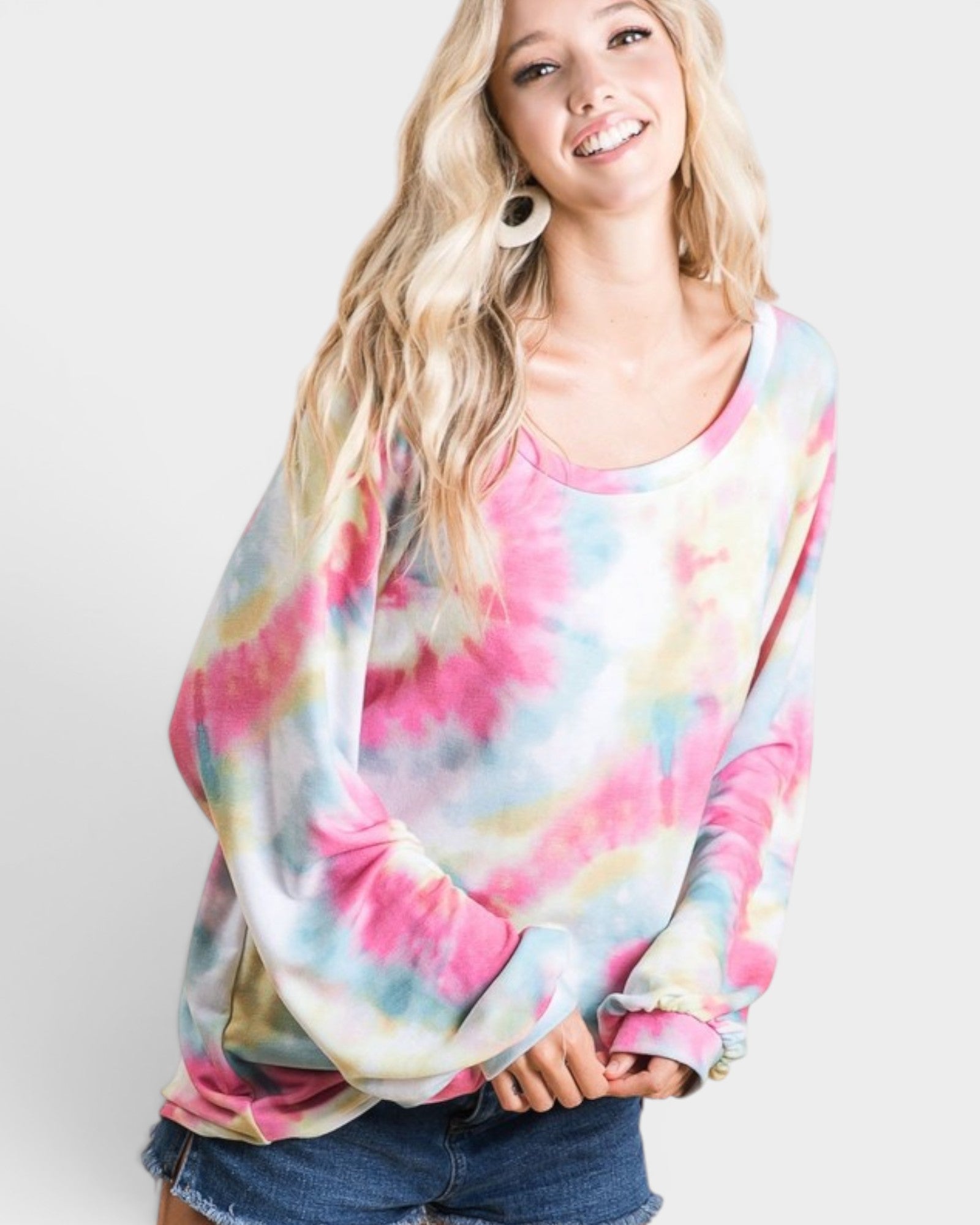 Woman wearing a colorful tie-dye shirt against a white background