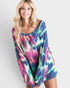 Woman wearing a colorful tie-dye dress against a white background