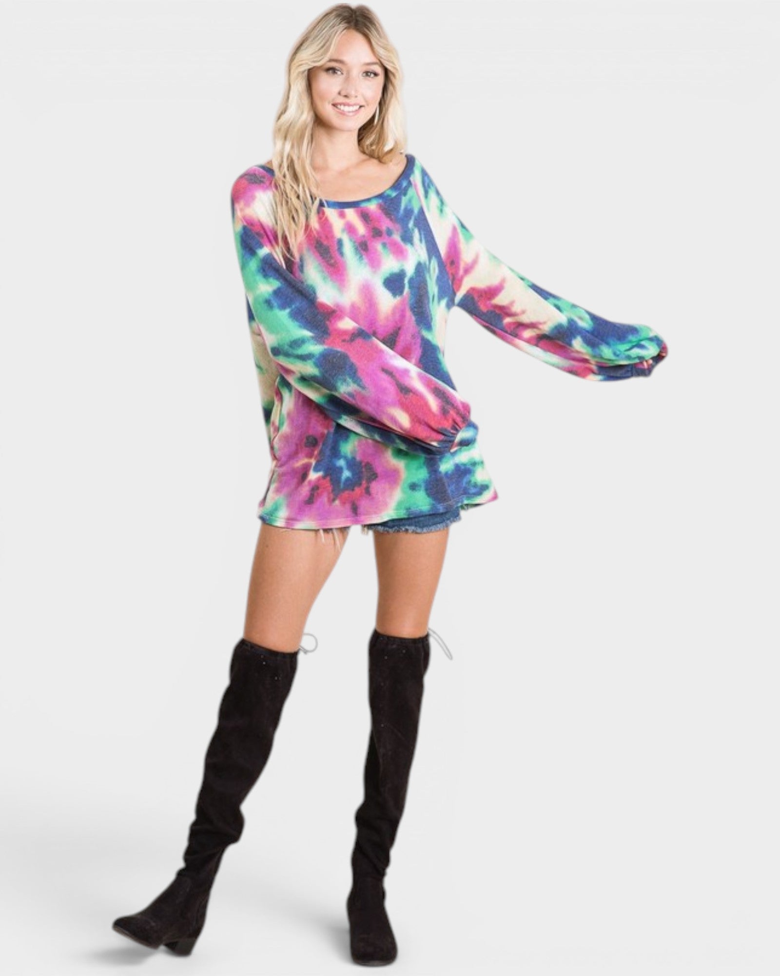 Person wearing a colorful tie-dye dress with long sleeves on a white background