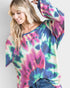 Woman wearing a colorful tie-dye sweater against a plain background
