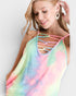 Woman wearing a colorful tie-dye tank top with strappy details on a plain background