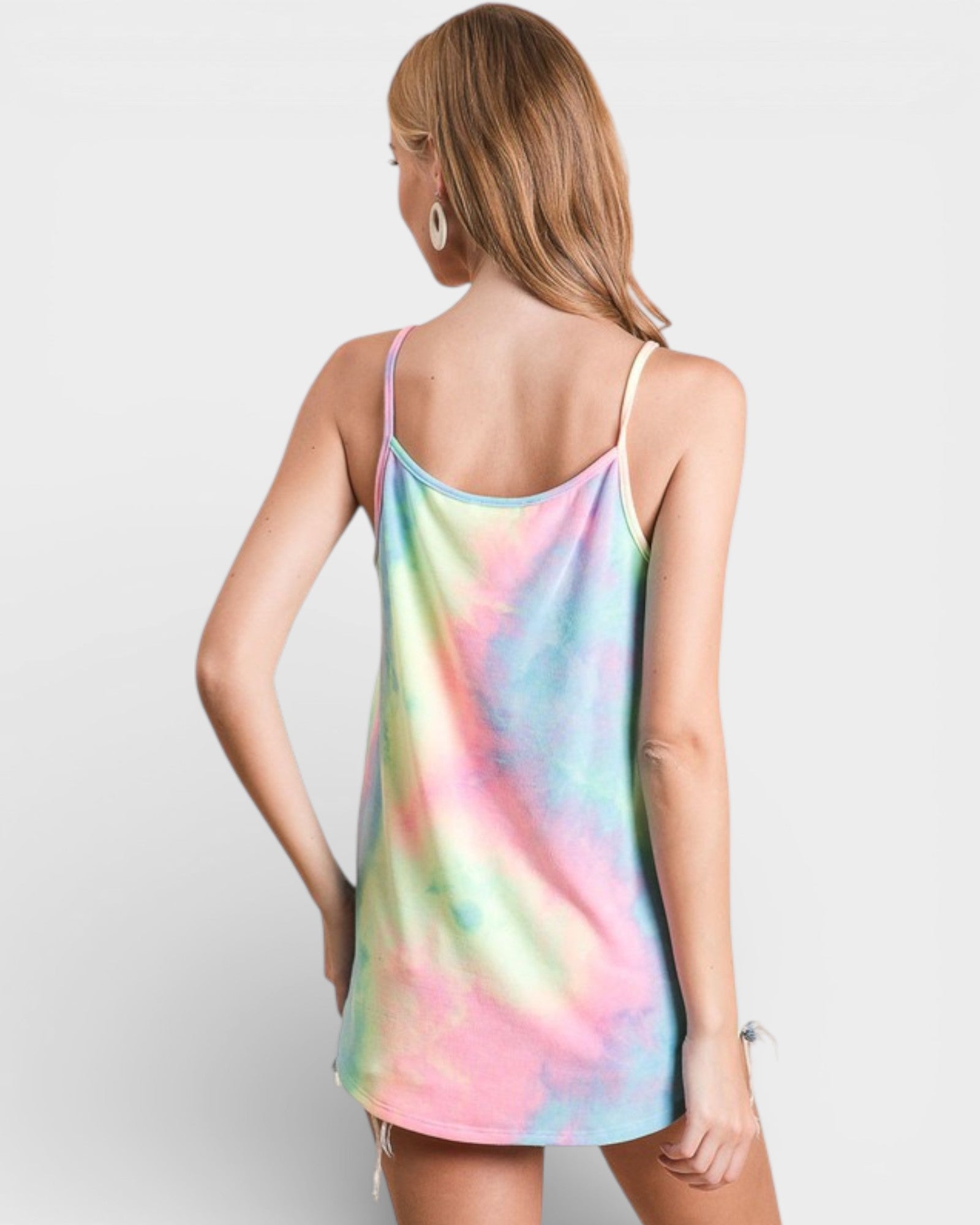 Woman wearing a tie-dye dress on a plain background