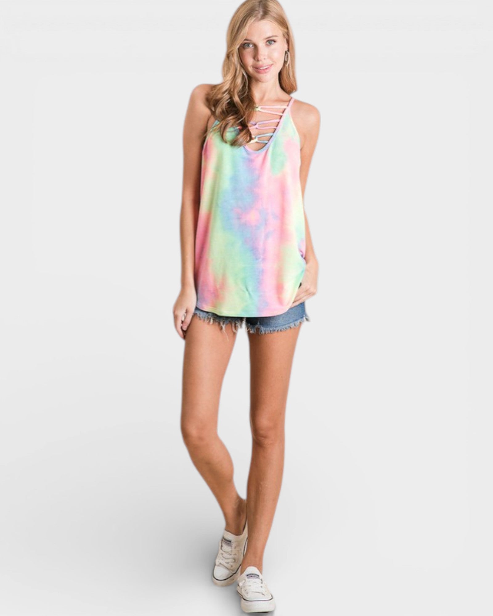Woman wearing a tie-dye tank top and denim shorts on a white background