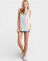 Woman wearing a tie-dye tank top and denim shorts on a white background