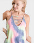 Woman wearing a tie-dye tank top with criss-cross straps on a white background