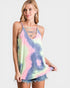 Woman wearing a tie-dye tank top with cut-out straps on a white background