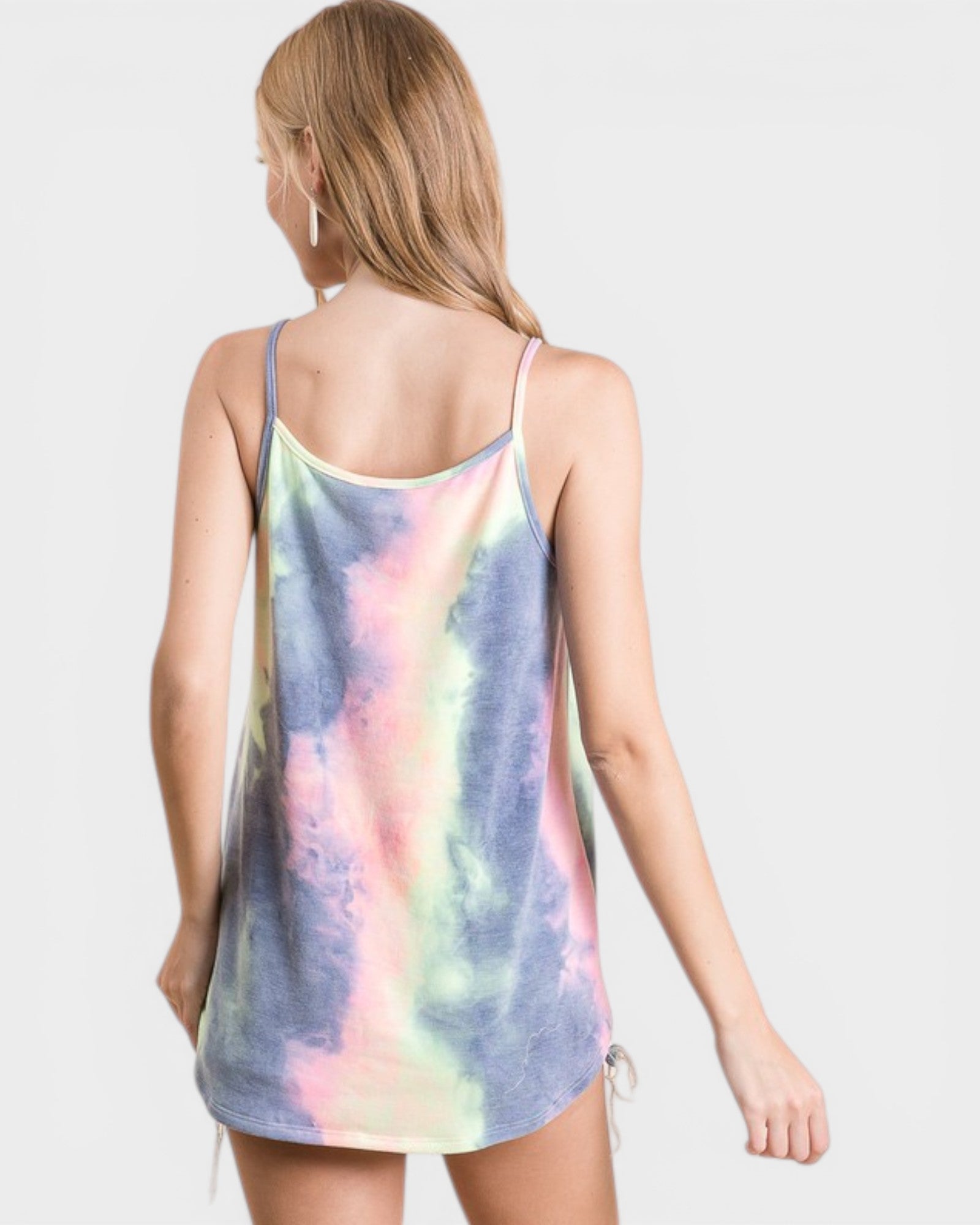 Woman wearing a tie-dye tank top against a plain background
