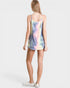 Woman wearing a tie-dye tank top on a plain background
