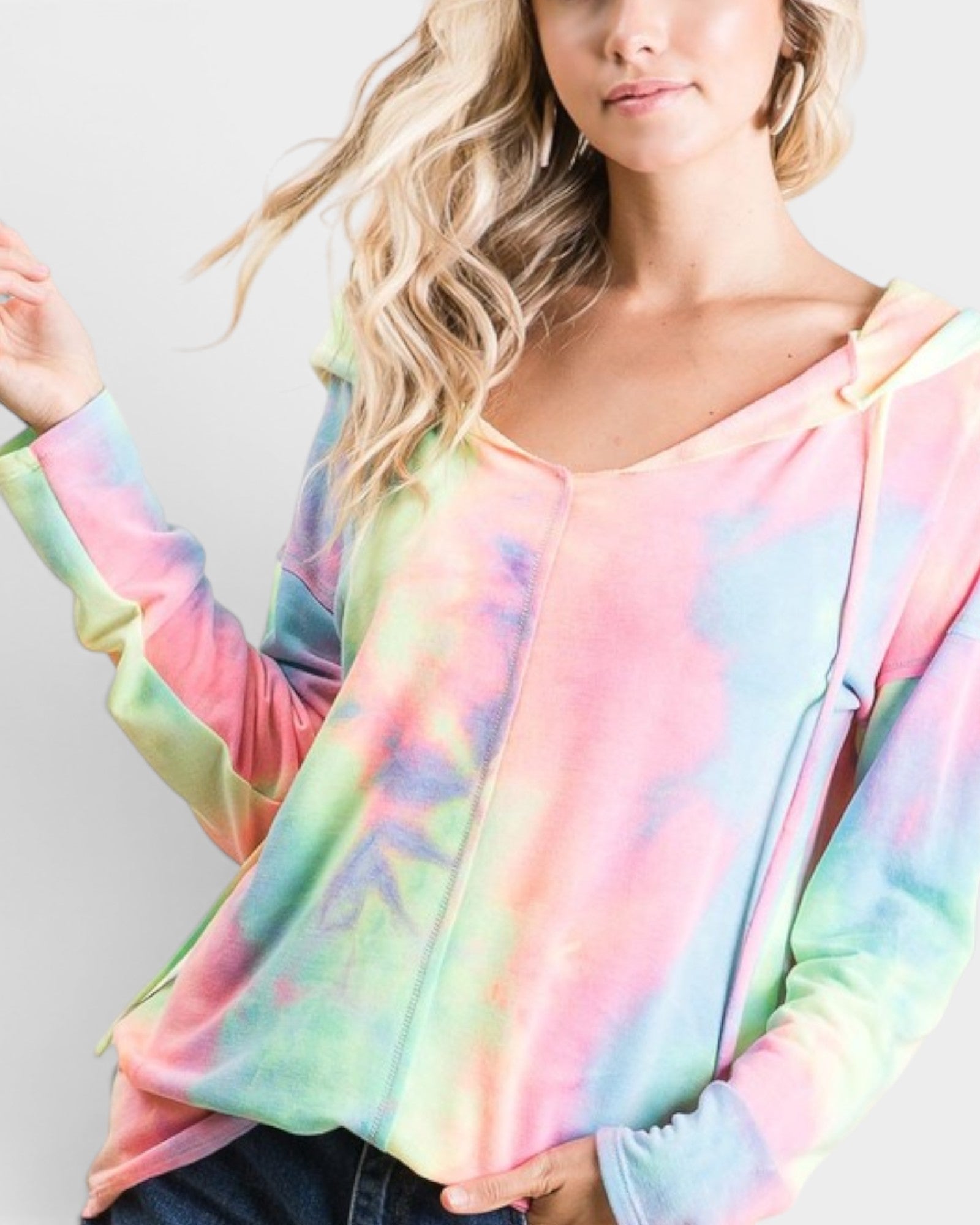 Woman wearing a colorful tie-dye long-sleeve top against a plain background