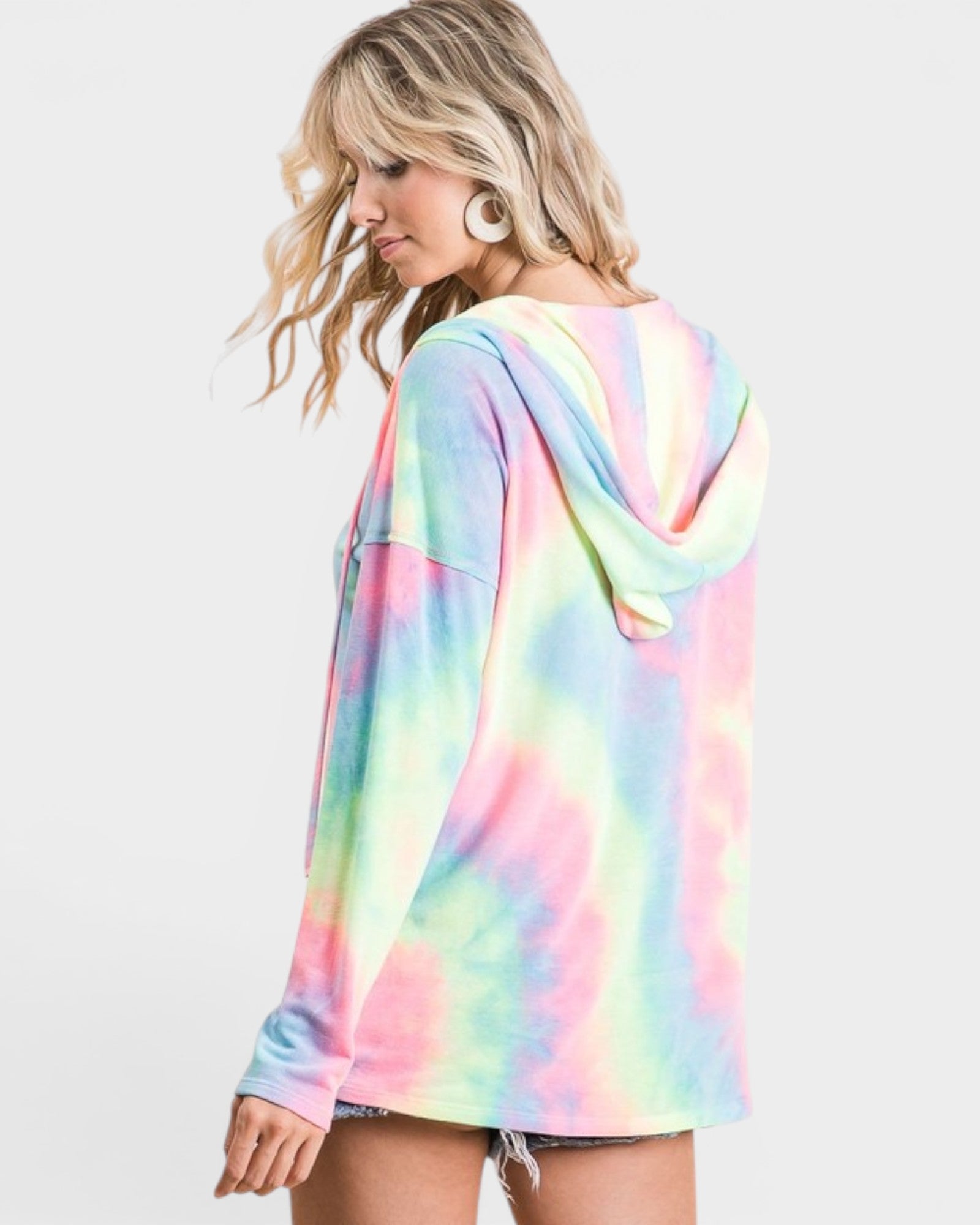 Woman wearing a colorful tie-dye hoodie on a white background