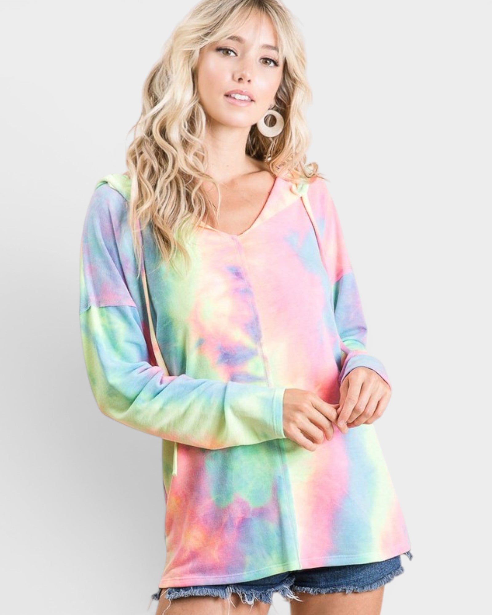 Woman wearing a colorful tie-dye shirt with a plain background