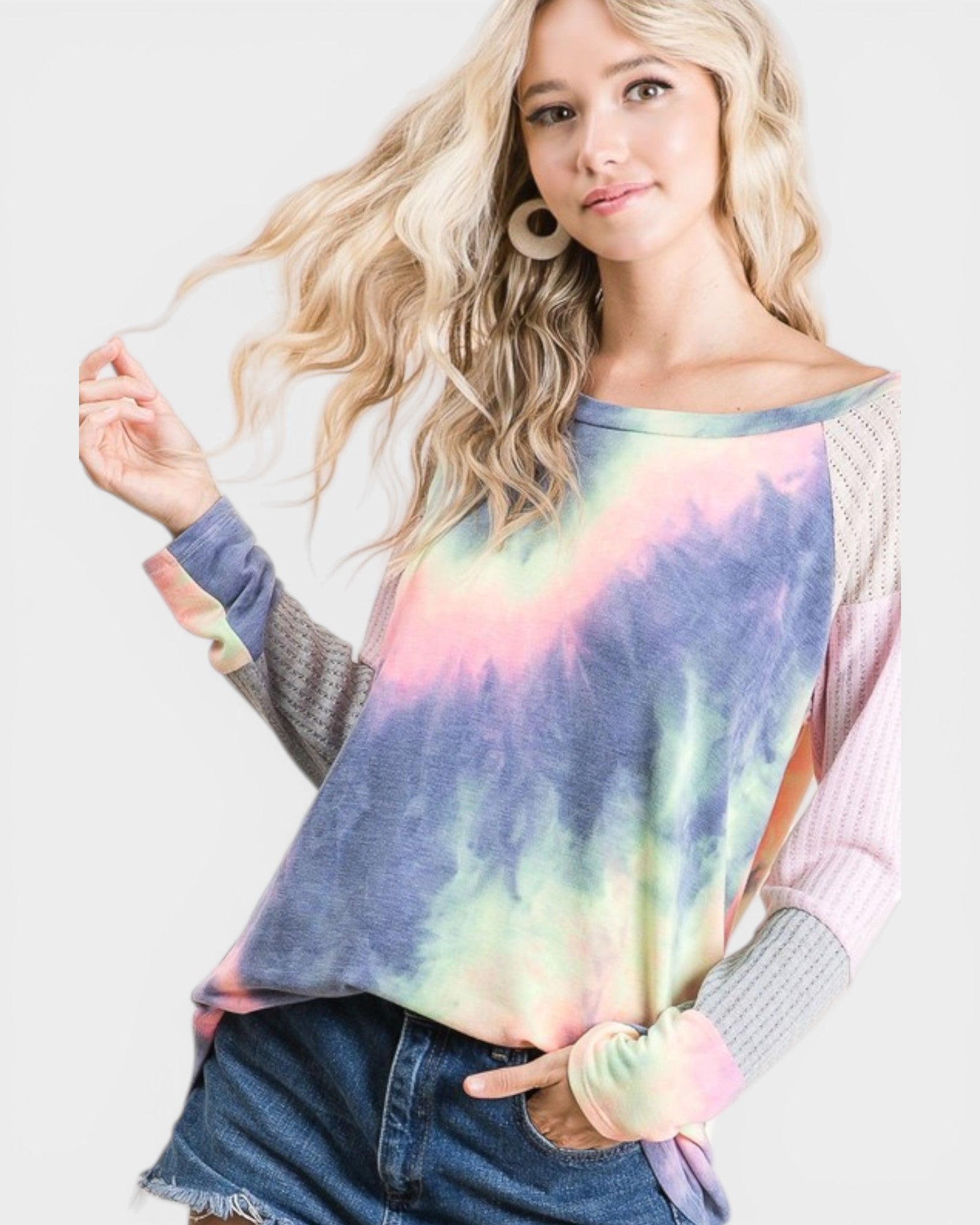 Woman wearing a tie-dye sweater with a plain background