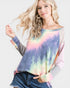 Woman wearing a tie-dye sweater with a plain background