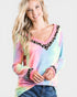 Woman wearing a colorful tie-dye long-sleeve shirt with leopard print accents on a white background
