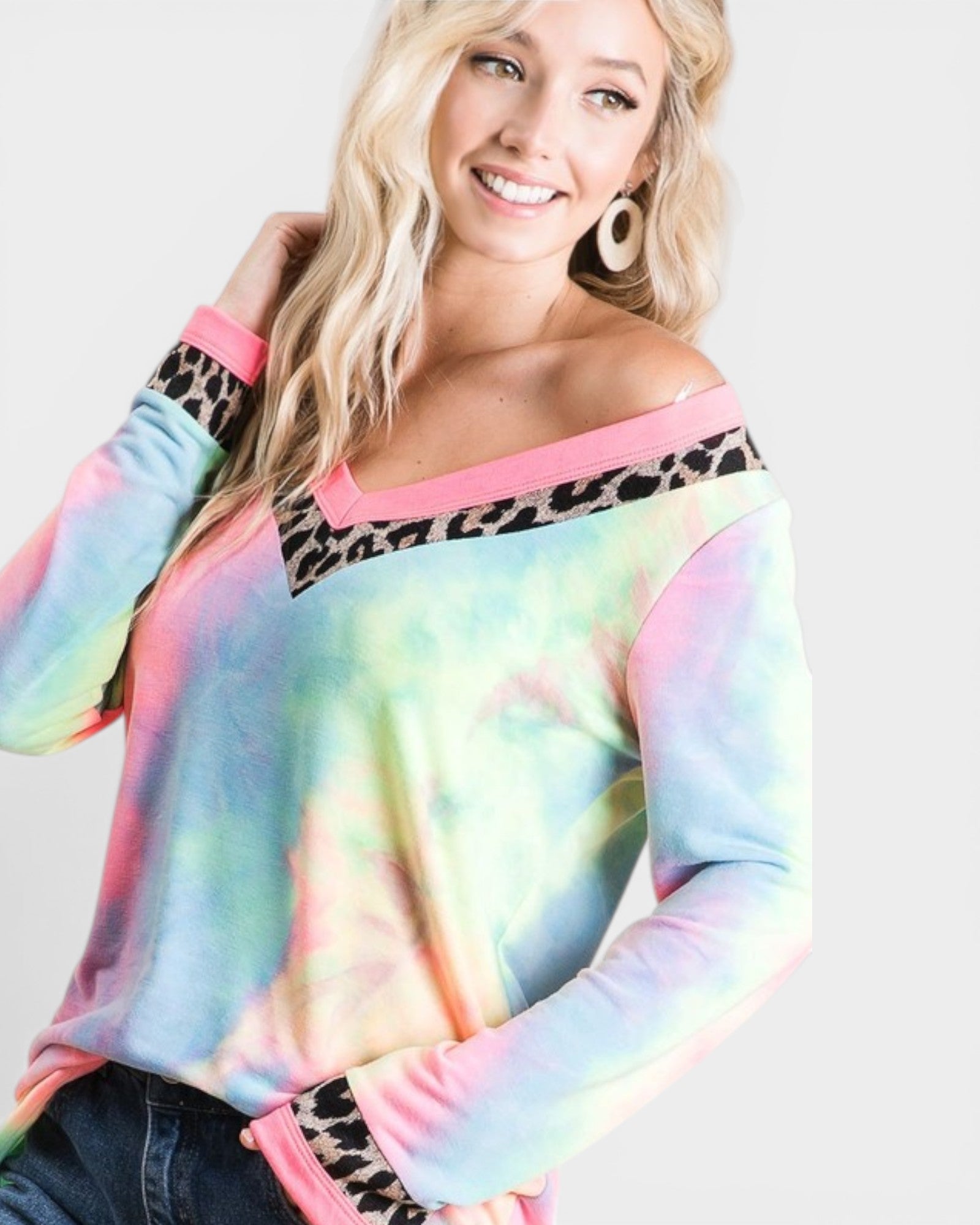Woman wearing a colorful tie-dye sweatshirt with leopard print accents on a white background