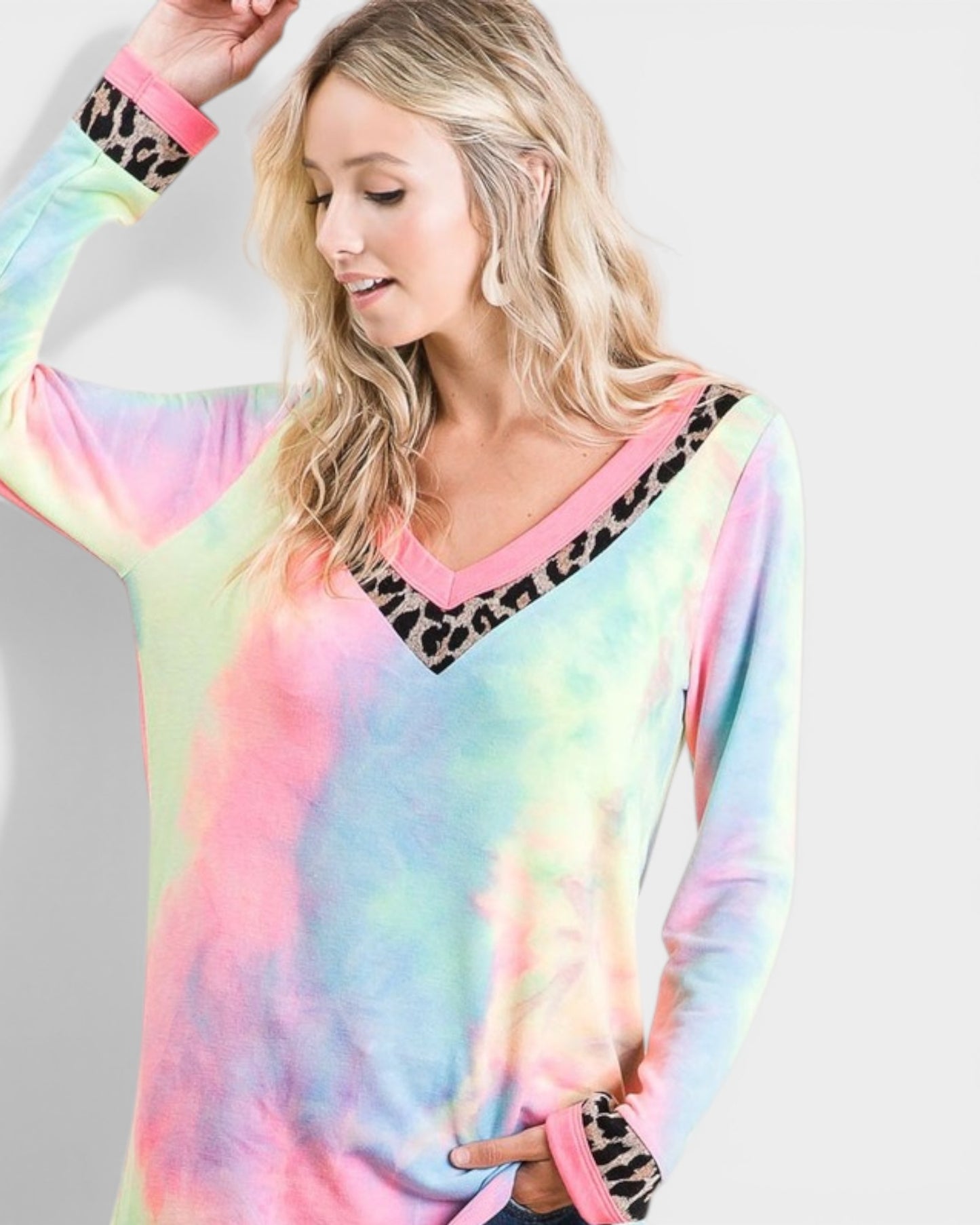 Woman wearing a colorful tie-dye sweater with leopard print accents on a white background