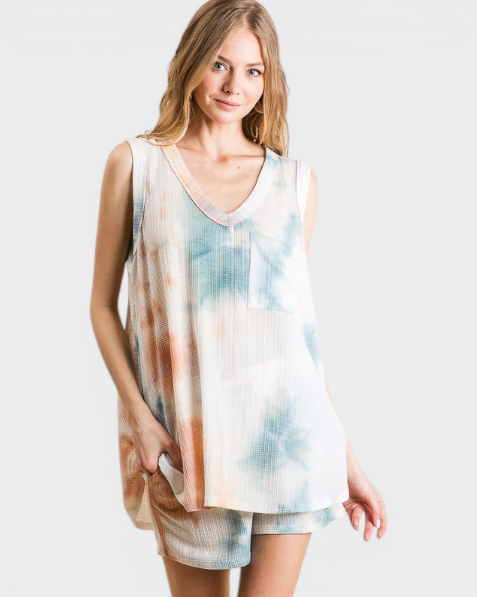 Woman wearing a tie-dye dress on a plain background